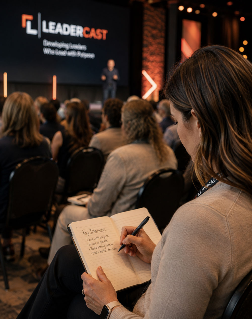 An attendee taking notes during a Leadercast session